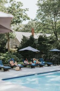a group of people sitting in chairs by a pool at Cape Arundel Inn and Resort in Kennebunkport