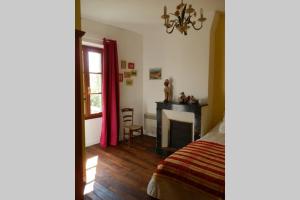 um quarto com uma cama, uma secretária e uma janela em La maison d'Auguste em Blaudeix