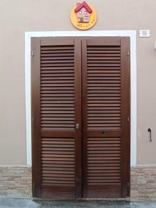 une paire de portes en bois sur le côté du bâtiment dans l'établissement B&B la piccola maison, à Ploaghe