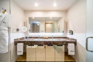 uma casa de banho com 2 lavatórios e um espelho grande em Barceló la Nucía Hills em La Nucía