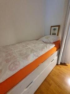 ein Schlafzimmer mit einem Bett mit einer orangefarbenen Matratze in der Unterkunft Apartment mit Blick auf das Eversten Holz 42qm in Oldenburg