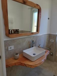 La salle de bains est pourvue d'un lavabo blanc et d'un miroir. dans l'établissement "Nonna Maria", à Venegono Superiore