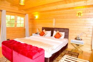 a bedroom with a large bed and a red couch at Severine Cottages and Lounge Ltd in Nairobi