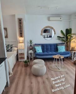 a living room with a blue couch and a table at Apartment Fuengirola Carvajal beach front Málaga Spain in Fuengirola