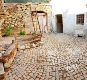 a brick courtyard with a bench and a building at Casa borghetto in Cancellara