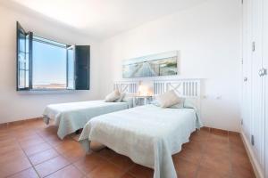 Dos camas en una habitación con paredes blancas. en Esencias del Mar & Wifi, en Porís de Abona