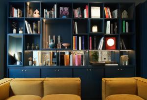 a living room with a book shelf filled with books at Hôtel Amoi Paris in Paris