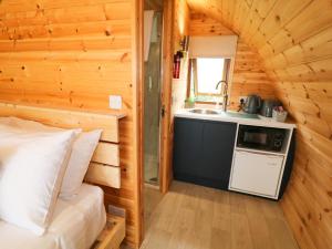a small kitchen in a log cabin with a sink at Pod 3 in Ballymoney