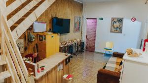 a living room with a yellow refrigerator and a staircase at Hostel Paraíso in Arraial do Cabo