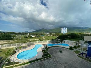 a view of a swimming pool with mountains in the background at Tom Ocean Club con vista al mar piso 15 bello horizonte santa marta carrera 3 #110-55 bello orizonte santa marta in Gaira