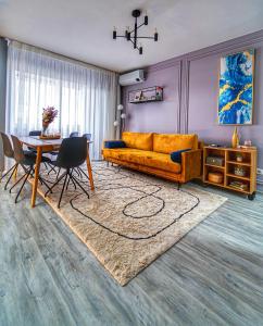 - un salon avec un canapé jaune et une table dans l'établissement Delux Suite, à Bacău