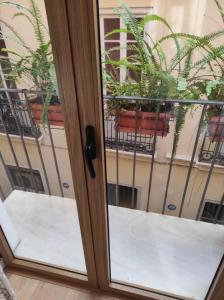a sliding glass door with potted plants on a balcony at APARTAMENTOS En Plom in Valencia