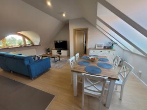 a dining room and living room with a table and chairs at Apartamenty Milenijna 2 MALBORK Nowa Wieś in Malbork