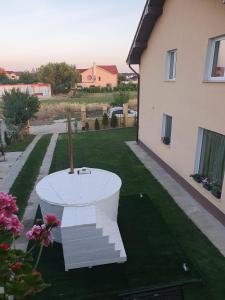 a white table in a yard next to a house at Vila Ardelean in Sînmartin