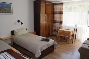 a bedroom with a bed and a table and a chair at Mildos butas in Birštonas
