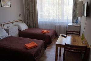 pokój hotelowy z 2 łóżkami, stołem i oknem w obiekcie Mildos butas w mieście Birsztany