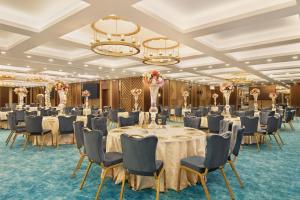 um salão de banquetes com mesas, cadeiras e lustres em Days Hotel by Wyndham Istanbul Maltepe em Istambul