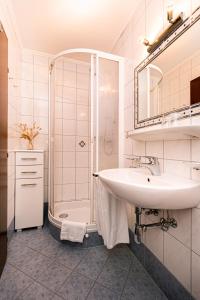 a white bathroom with a sink and a shower at Haus Farmer in Sankt Martin am Tennengebirge