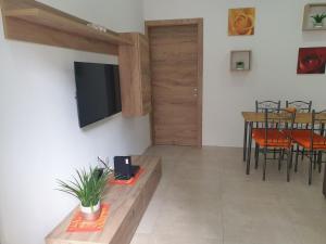 a living room with a television and a table with chairs at Modern Apartment in Central Bugibba in St. Paul's Bay