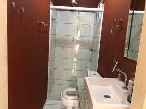 a bathroom with a shower with a toilet and a sink at Charmosa Casa pertinho do morro do céu in Laguna