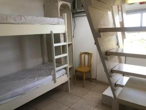 a room with two bunk beds and a chair at Charmosa Casa pertinho do morro do céu in Laguna