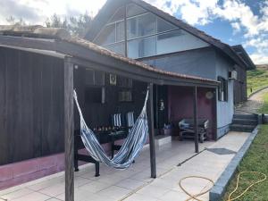 a house with a hammock on a patio at Charmosa Casa pertinho do morro do céu in Laguna