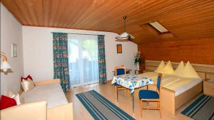 ein Wohnzimmer mit einem Tisch, Stühlen und einem Sofa in der Unterkunft Ferienwohnung Neuhuber in Bad Goisern