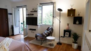a bedroom with a chair and a bed and a window at Lavena - LAKE & MOUNTAIN Apartments in Lavena Ponte Tresa