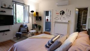 a bedroom with a bed and a flat screen tv at Lavena - LAKE & MOUNTAIN Apartments in Lavena Ponte Tresa