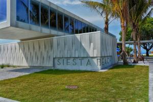 een gebouw met het siësta-eilandbord ervoor bij Siesta Key Village-Suite #4: A block to the Beach! in Sarasota