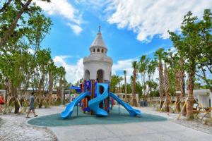 a playground with a slide in front of a tower at Siesta Key Village-Suite #4: A block to the Beach! in Sarasota