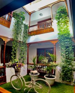 a bike parked in front of a house with plants at Apartamentos Tapahuga in Playa de Santiago