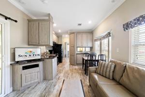 a living room with a couch and a kitchen at Sun Outdoors Sarasota in North Sarasota