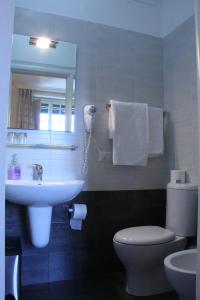 罗马马志尼住宿旅馆的浴室里有洗手池、马桶和镜子。