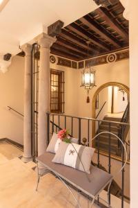 a room with a bench and a chandelier at Palacete 1620, Premium Suites, Only adults in Granada
