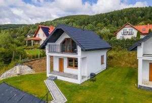 an aerial view of a white house with a black roof at Domki Wincentego in Ustrzyki Dolne