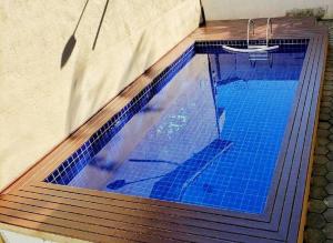a large swimming pool with a blue at Flat Vila da Arara in Maresias