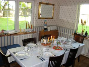 a dining room table with a white table cloth and candles at Maple House - Sodyba Tarp Klevų in Utena