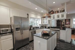 a kitchen with white cabinets and stainless steel appliances at Dickson Street Bed & Breakfast in Fayetteville
