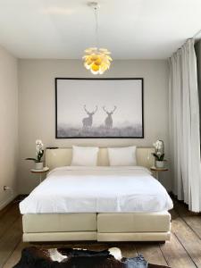 a bedroom with a large white bed and two deer paintings at Loft O - River View in Antwerp