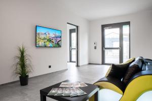 a living room with a couch and a tv on a wall at Hotel Grüne Elster in Fürth