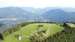 an aerial view of a green field with mountains at Al Tajol in Lamon