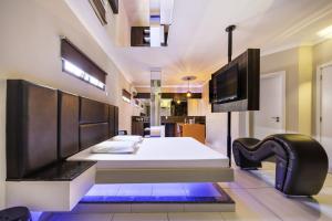 Savanas Motel في بونتا غروسا: غرفة نوم بسرير وتلفزيون بشاشة مسطحة