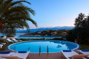 uma piscina com cadeiras e vista para a água em Seafront Villa Longobardi em Chania Town