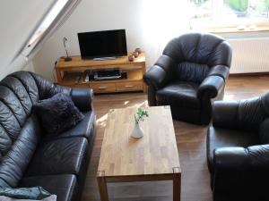 a living room with two leather couches and a coffee table at Beautiful holiday home with sauna in Schieder-Schwalenberg