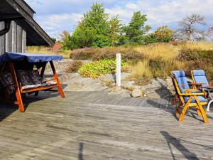 6 person holiday home in HEN N في Sundsandvik: كرسيين وطاولة على سطح خشبي
