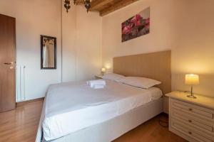 um quarto com uma grande cama branca e uma cómoda em il borgo appartamenti con parcheggio em Malcesine