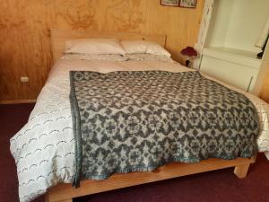 uma cama com um cobertor castanho e branco em Victor-alojamientos em La Serena