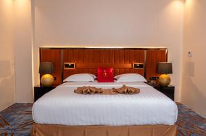 a bedroom with a large bed with a red pillow at Hôtel Fleur de Lys Point E in Dakar