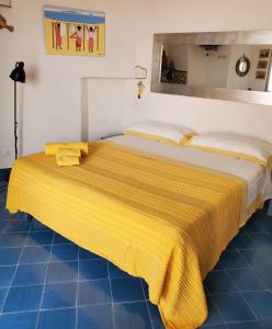 - un lit avec une couverture jaune au-dessus dans l'établissement Agata Suite, à Ischia
